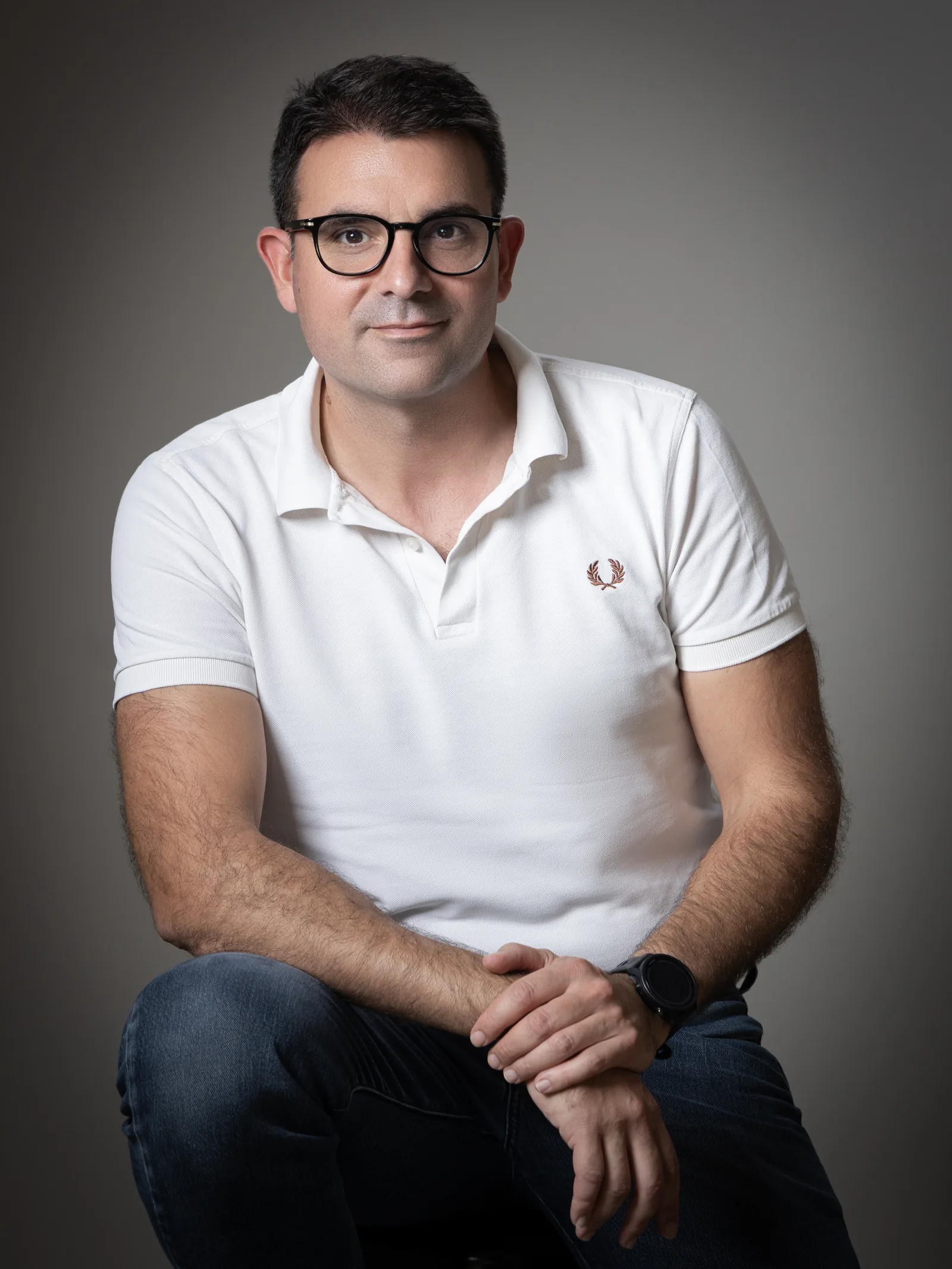 Portrait d'homme souriant en polo blanc, séance portrait en studio à Montesson